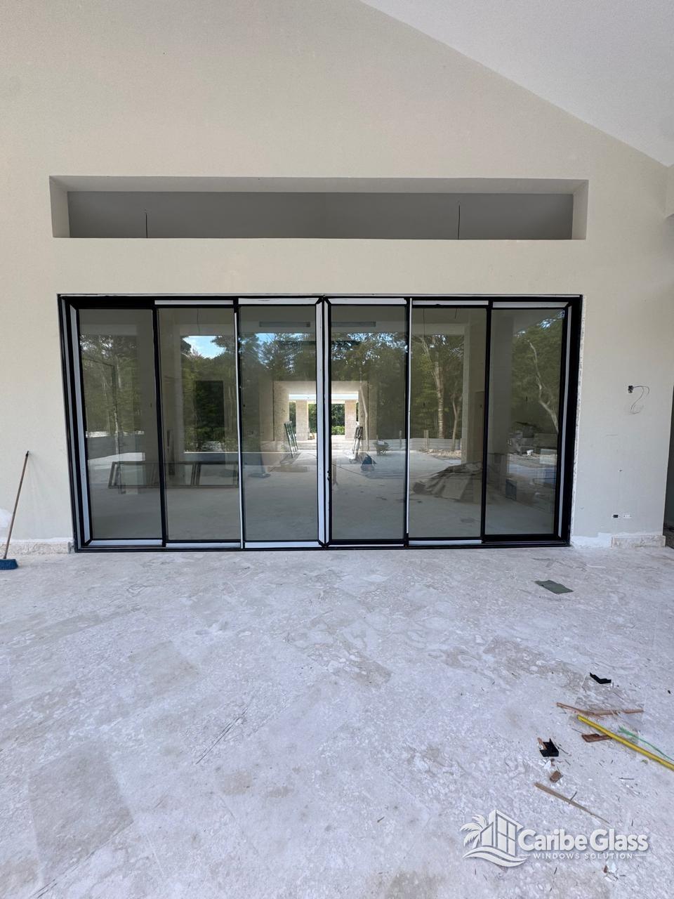 Instalación de gran ventanal corredizo de 6 hojas en cristal templado y aluminio negro en Punta Cana - Caribe Glass Windows Solution